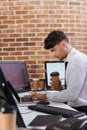 young businessman sitting near computers, smartphone