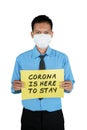 Businessman holding text of Corona is here to stay Royalty Free Stock Photo