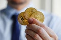 Man holding three Bitcoin coins in hand