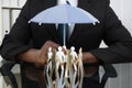 Businessman Holding Umbrella Over Paper Cutout People Royalty Free Stock Photo