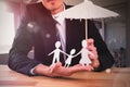 Composite image of businessman holding umbrella and paper family Royalty Free Stock Photo