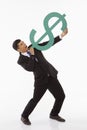 Businessman holding up a dollar sign, showing shooting gesture