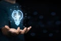 Businessman holding virtual light bulb and half brain on blue bokeh background smart thinking concept and innovative ideas Royalty Free Stock Photo