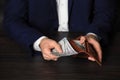 Businessman holding wallet with dollar bills at table, closeup Royalty Free Stock Photo