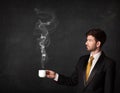 Businessman holding a white steamy cup