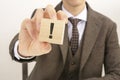 businessman holding wooden block with the exclamation point Royalty Free Stock Photo
