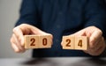 Businessman holding wooden blocks 2024. Business plan and strategy concept. Planning. Targets and goals. Financial plans, Royalty Free Stock Photo