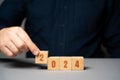 Businessman holding wooden blocks 2024. Business plan and strategy concept. Planning. Targets and goals. Financial plans, Royalty Free Stock Photo