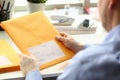 Businessman holding yellow package with mail in office Royalty Free Stock Photo