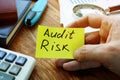 Businessman holds Audit Risk sign on a sheet