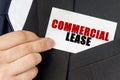 Businessman holds a card with the text - COMMERCIAL LEASE