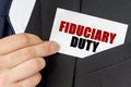 Businessman holds a card with the text - FIDUCIARY DUTY