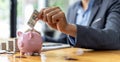 Businessman holds dollar bills in a piggy bank. Placing coins in a row from low to high is comparable to saving money to grow more