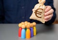 A businessman holds a euro money bag near a group of people figurines. Preferential loans for entrepreneurs and businesses.