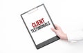 A businessman holds a folder with paper sheet with the text Client Testimonials . Business concept Royalty Free Stock Photo