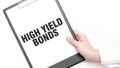 A businessman holds a folder with paper sheet with the text HIGH YELD BONDS. Business concept Royalty Free Stock Photo