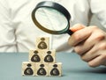 Businessman holds magnifying glass over cubes with euro. Analysis of profits and revenues in the company. Distribution of money. Royalty Free Stock Photo