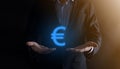 Businessman holds money coin icons EUR or Euro on dark tone background..Growing money concept for business investment and finance Royalty Free Stock Photo