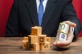 A businessman holds out a bundle of euros near a pile of boxes. Superprofits. Investments financing in production, taxes, income Royalty Free Stock Photo