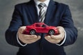 Businessman holds red toy car, illustrating car purchase concepts Royalty Free Stock Photo