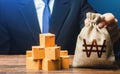 Businessman holds south korean won money bag and boxes with goods. Import and export. Business income. Payment of taxes and fees. Royalty Free Stock Photo