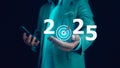 Businessman holds text 2025 with arrow target, Implementation of business goals plan, Set goals for 2025, Development to achieve