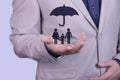 A businessman holds an umbrella on his hand, over a family concept, for protection, safety, finance and insurance Royalty Free Stock Photo