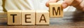 Businessman holds wooden blocks with the word Team. Team management concept. Teamwork. Hiring. Recruitment staff. Work in