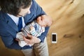 Businessman at home holding baby daughter in the arms.