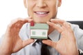 Businessman with house model by a desk.