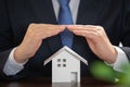 Businessman with house model on the desk. Real estate concept