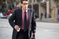 Businessman Hurrying Along Street Holding Takeaway Coffee