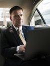 Businessman inside a car working on his laptop Royalty Free Stock Photo