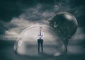 Businessman safely inside a shield dome during a storm that protects him from a wrecking ball. Protection and safety