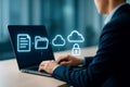 Businessman interacting with cloud storage and security icons on laptop screen computer technology Royalty Free Stock Photo