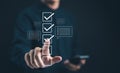 Businessman interacting with digital checklist interface. Correct sign mark in checkbox for quality control and business approve