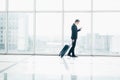 Businessman at international airport moving to terminal gate for airplane travel trip looking in phone in hand Royalty Free Stock Photo