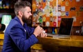 Businessman internet surfing drink alcohol. Hipster freelancer work online drinking cognac. Man bearded businessman bar