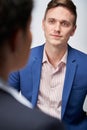 Studio Shot Of Businessman Interviewing Businesswoman For Employment Against White Background