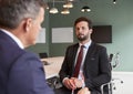 Businessman Interviewing Male Candidate At Graduate Recruitment Assessment Day In Office