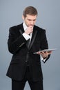 Businessman is intrigued by the news he is reading on his tablet pc