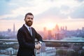 Businessman with jacket standing against London view panorama at sunset. Royalty Free Stock Photo