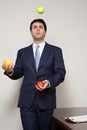 Businessman juggling fruit Royalty Free Stock Photo