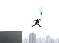 Businessman jumping from bulding top to catch glowing lamp balloon