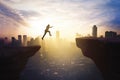 Businessman jumping through gap cliff at sunrise Royalty Free Stock Photo