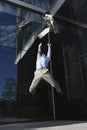 Businessman Jumping outside building throwing jacket and briefcase into air Royalty Free Stock Photo