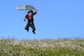 Businessman Jumping over Grass Hill Royalty Free Stock Photo