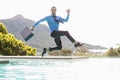 Businessman jumping over swimming pool