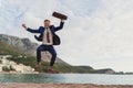 Businessman jumping by the sea Royalty Free Stock Photo