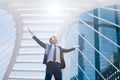 Businessman keeping arms raised and expressing positive while standing outdoors